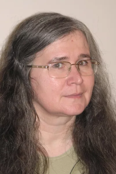 Barna hajú szemüveges nő zöld felsőben