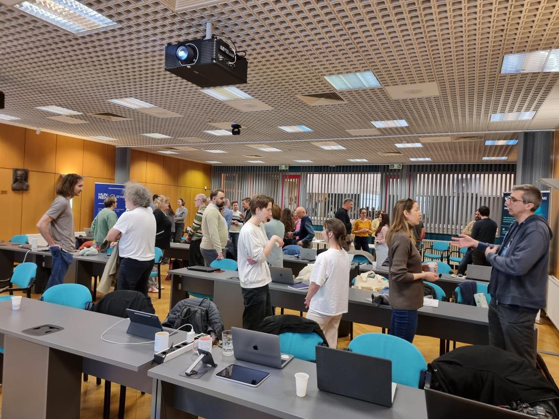 emberek párokban beszélgetnek egy nagy teremben