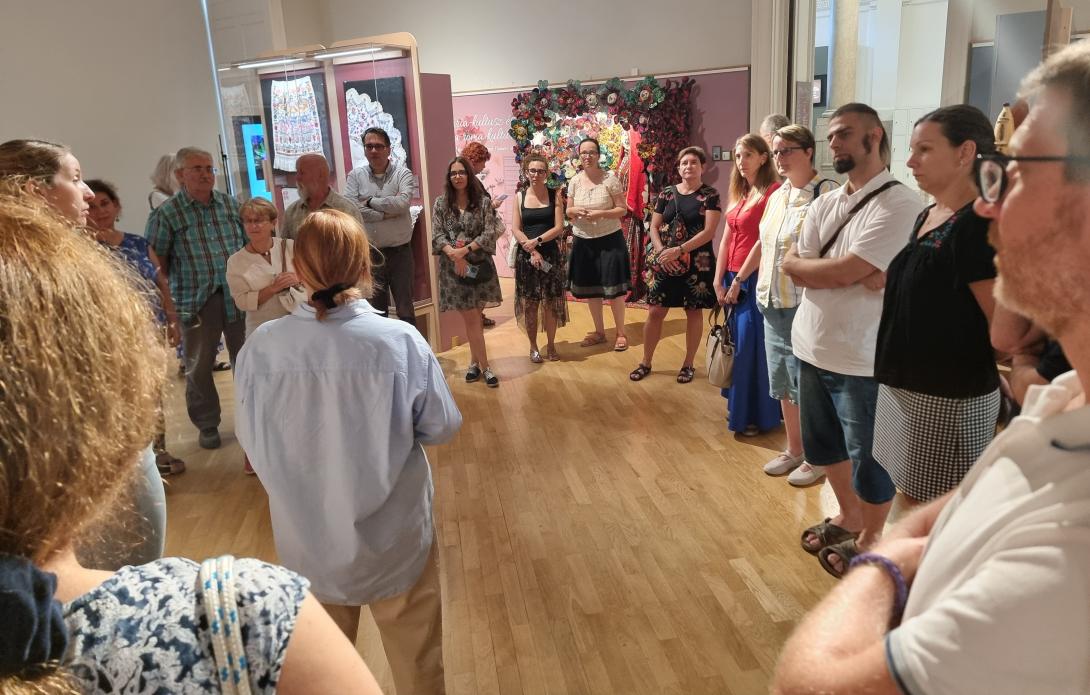 emberek egy csoportja előadást hallgat egy kiállítótérben