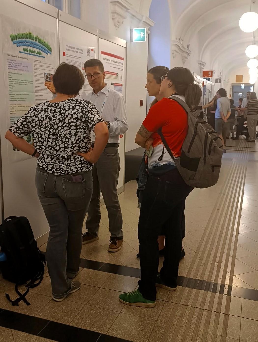 Poszter előtt beszélgető emberek